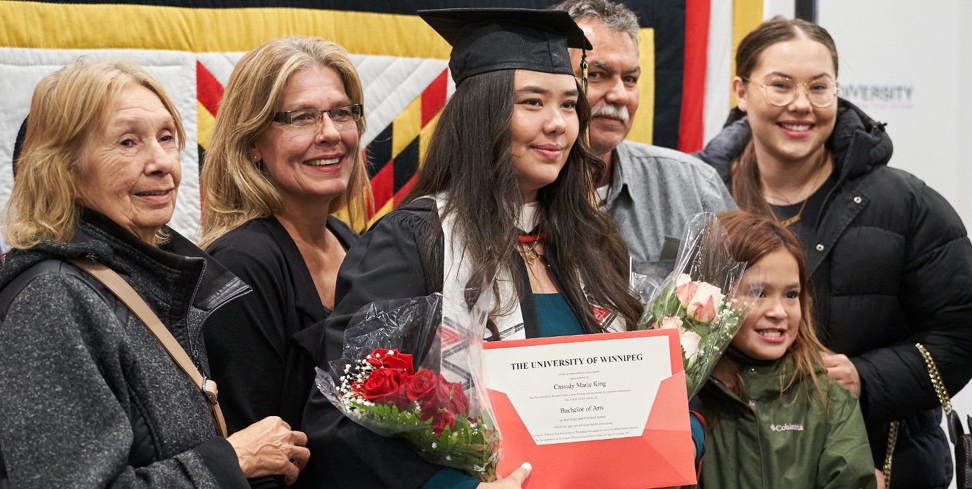 Family gathers around student for a photo at convocation