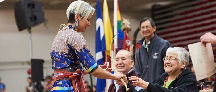 Indigenous graduate receiving a gift at the Annual Spring Pow-Wow
