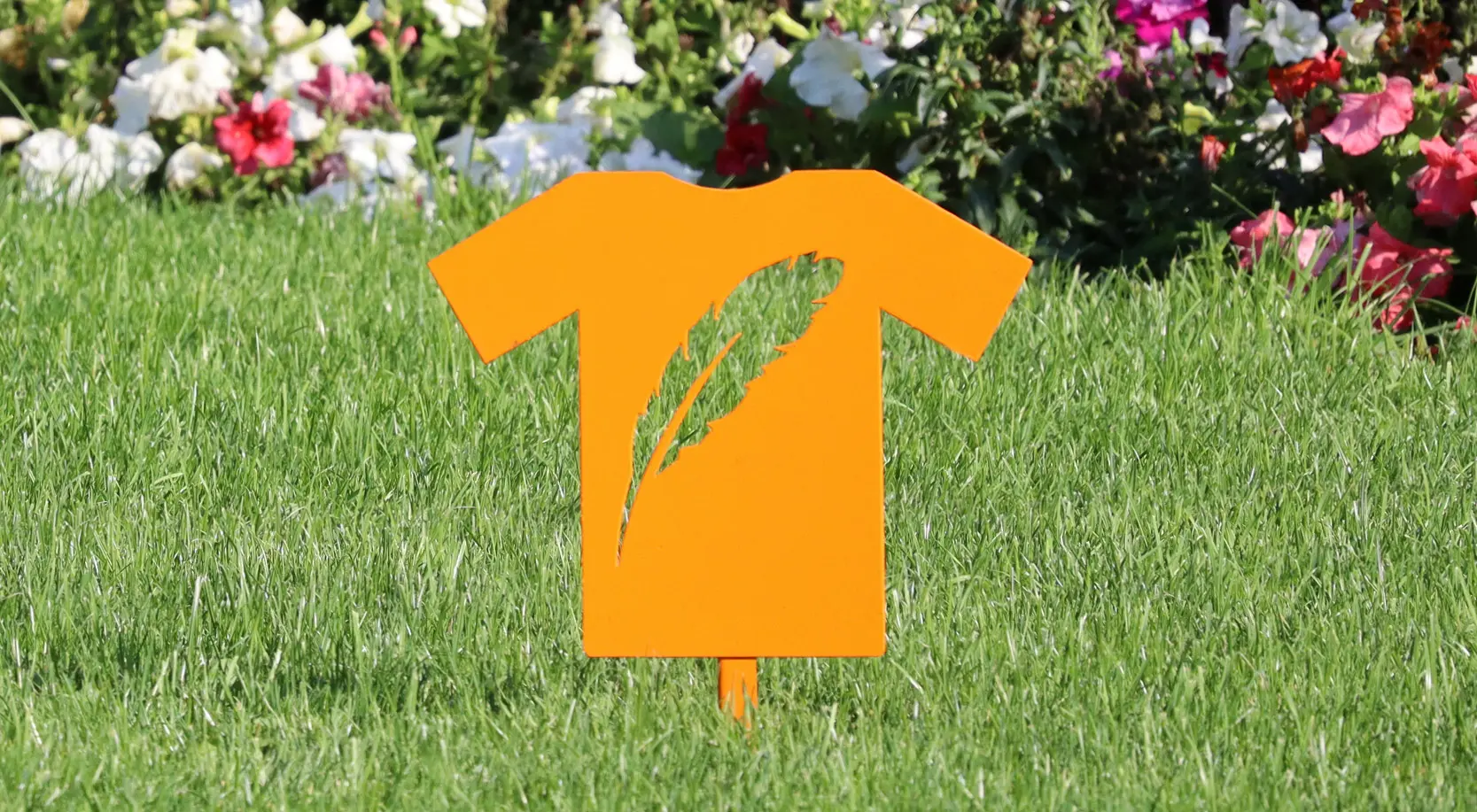Cutouts of an orange t-shirts are installed on a lawn. 