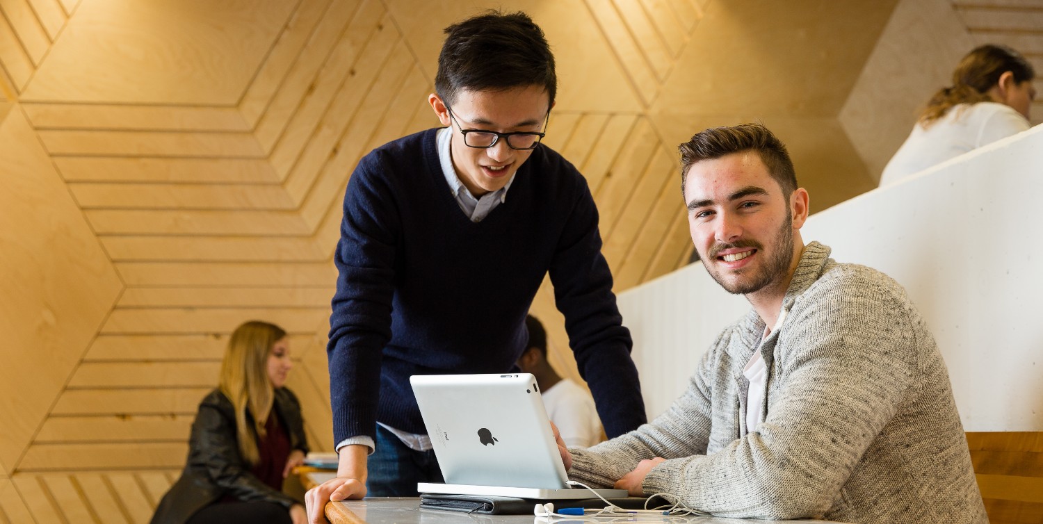 A student receives assistance on the computer