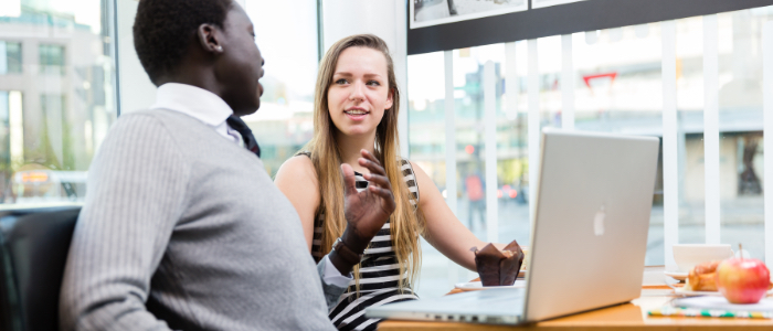 Two people at a computer having a discussion.