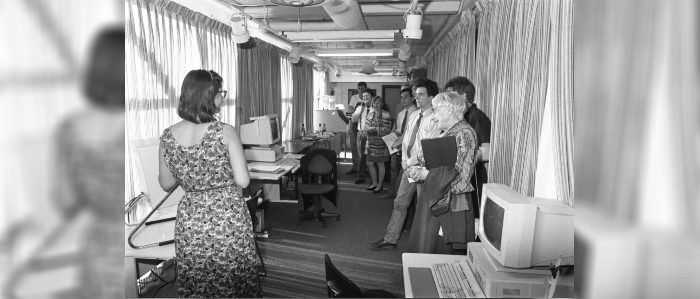 Black and white photo of computers on display in library