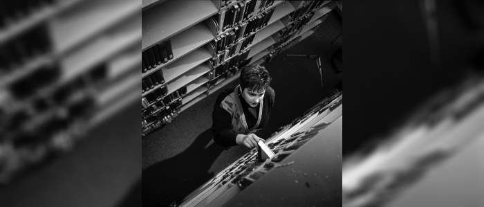 Black and white photo of person pulling book from library shelf