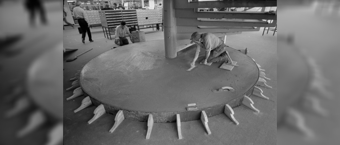 Black and white photo of concrete being troweled below library staircase