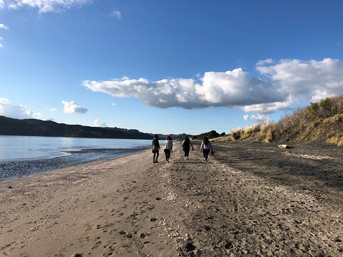 Walking with fellow MDP students on Te Kopua Beach in Raglan, Aotearoa 