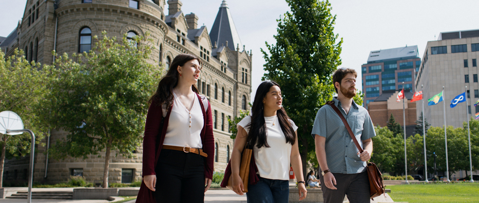 Three students walking in front of campus