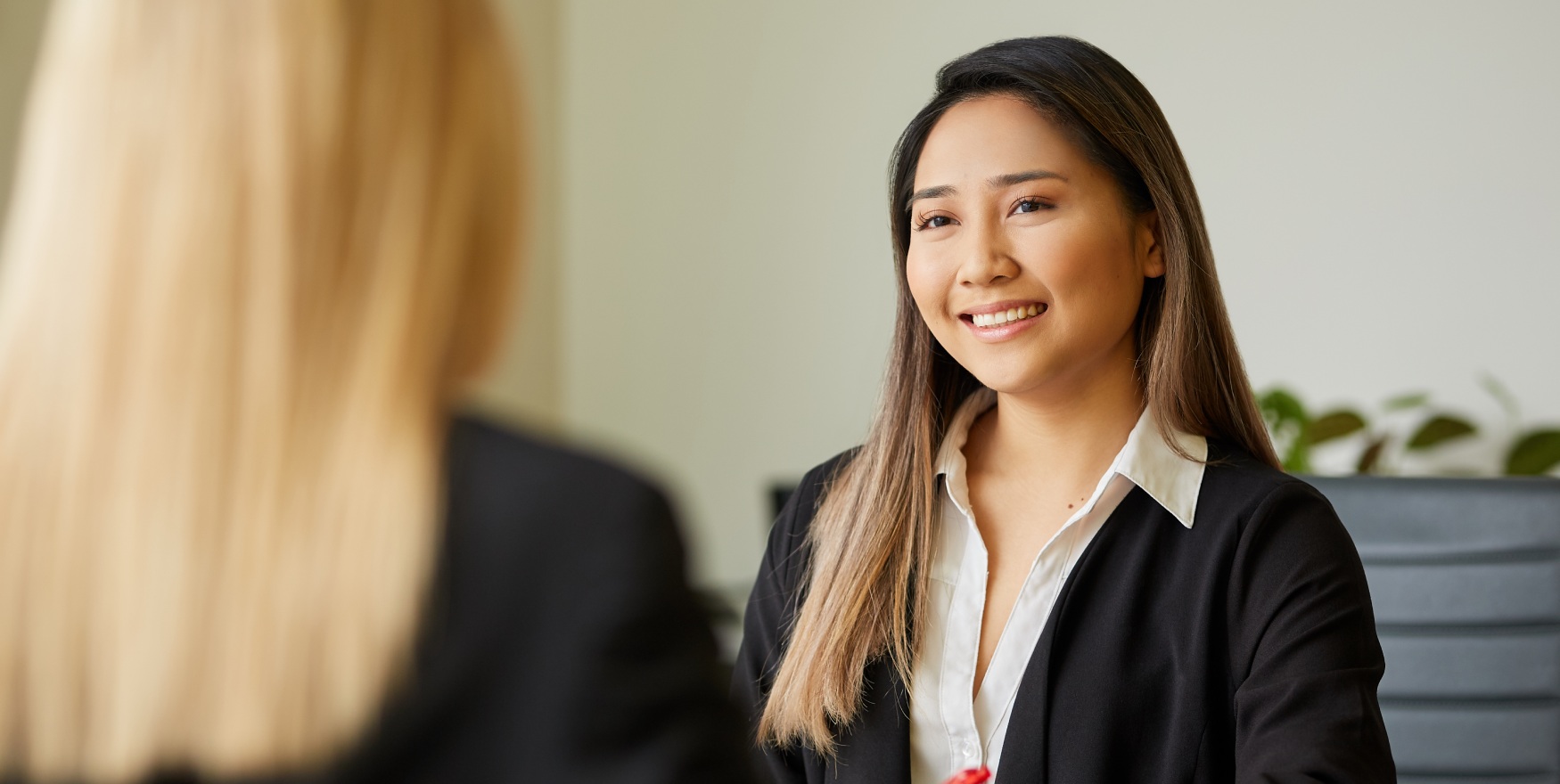 A woman in a suit smiles at the camera