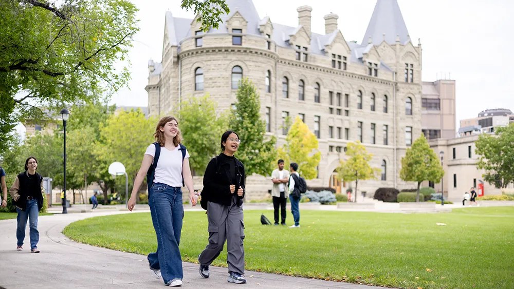 Two students walking and talking outside campus