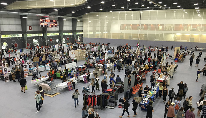 Indoor market set-up with vendors selling merchandise on field.
