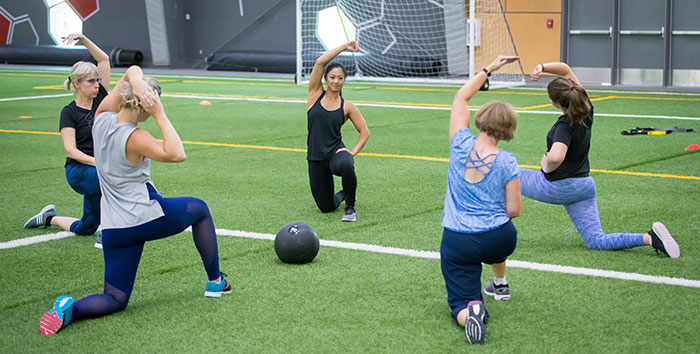 People stretching after a fitness class on the RecPlex field.