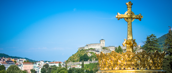 A gold cross overlooking scenery in France