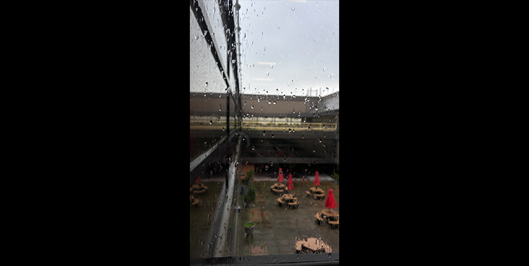 Raindrops on a window with a courtyard in the background