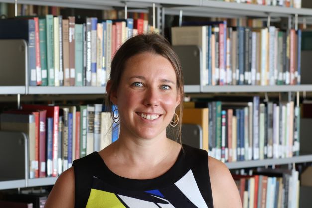 Natalie Richer in front of a bookshelf 