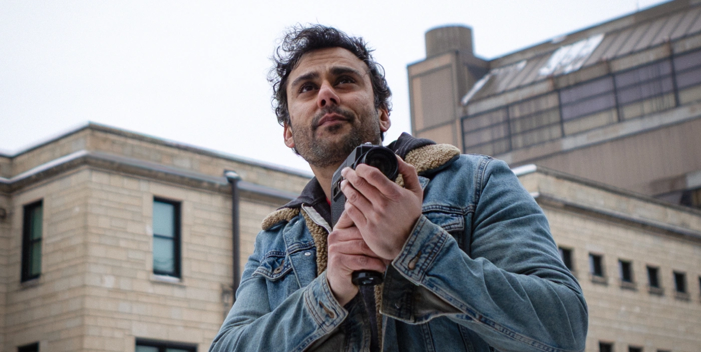 Alumni Ian Bawa looks into the distance while holding a video camera
