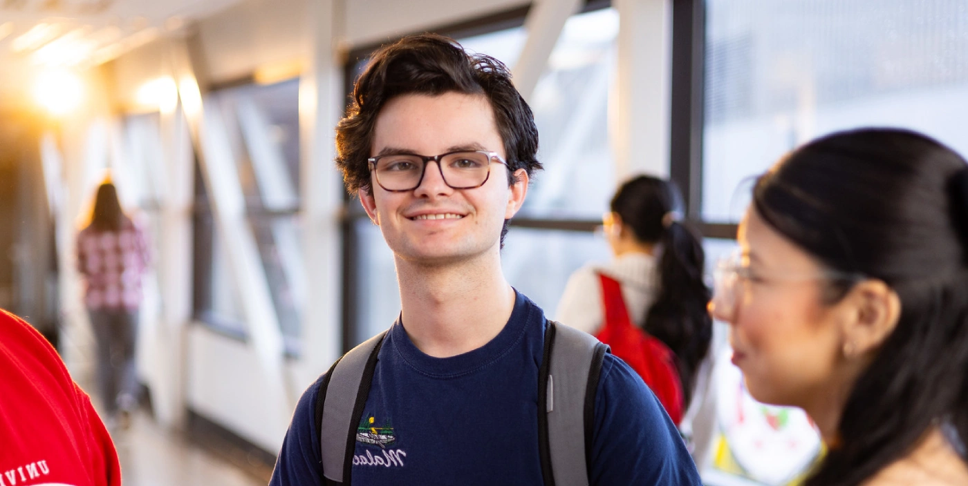 Student Thomas Hepworth smiles while standing with fellow students
