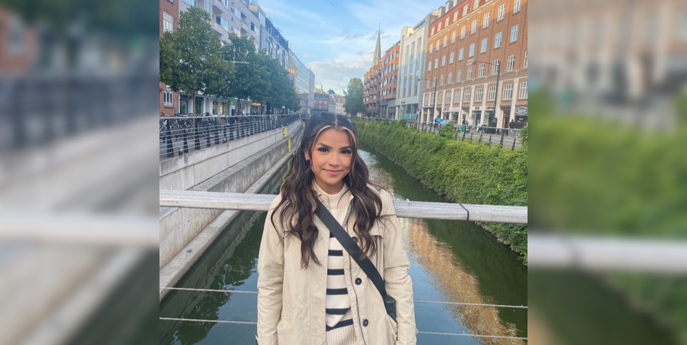 Jade smiling while standing on a footbridge spanning a canal