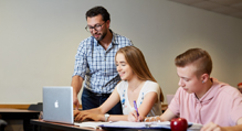 Faculty member with students at computer