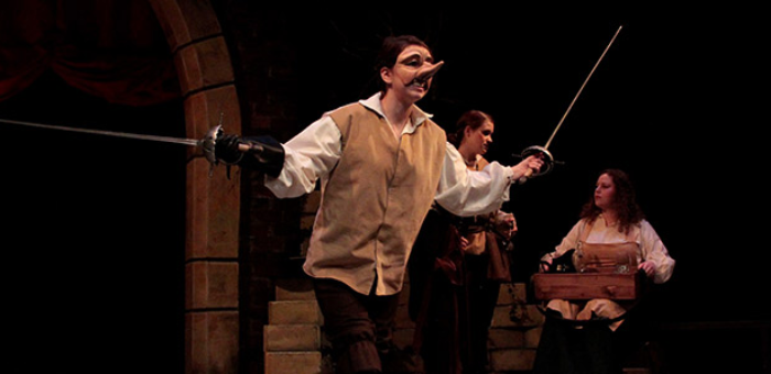 A spotlit performer on a darkened stage