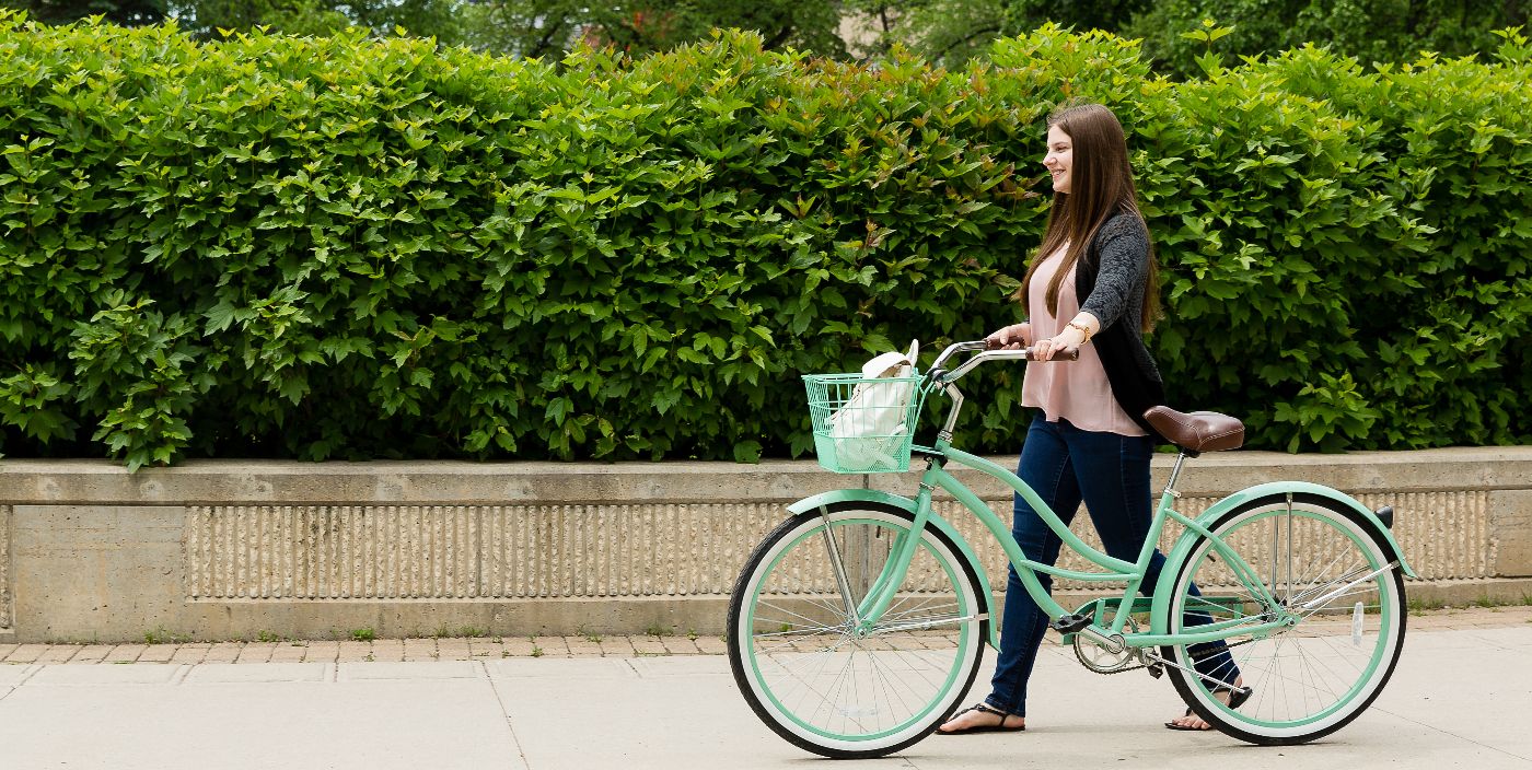 Person walking their bike in front of Wesley Hall