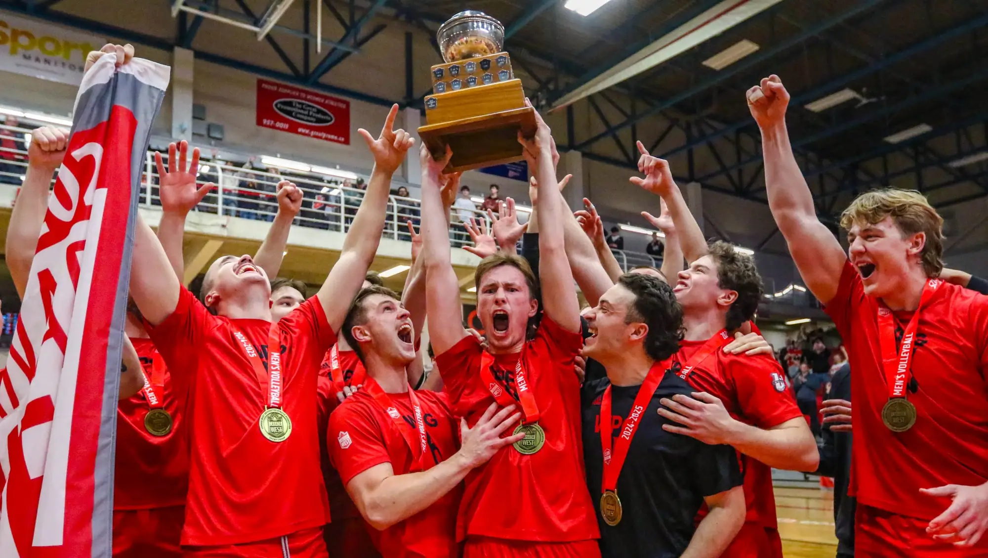Jubilated Wesmen players holding trophy above their heads and cheering