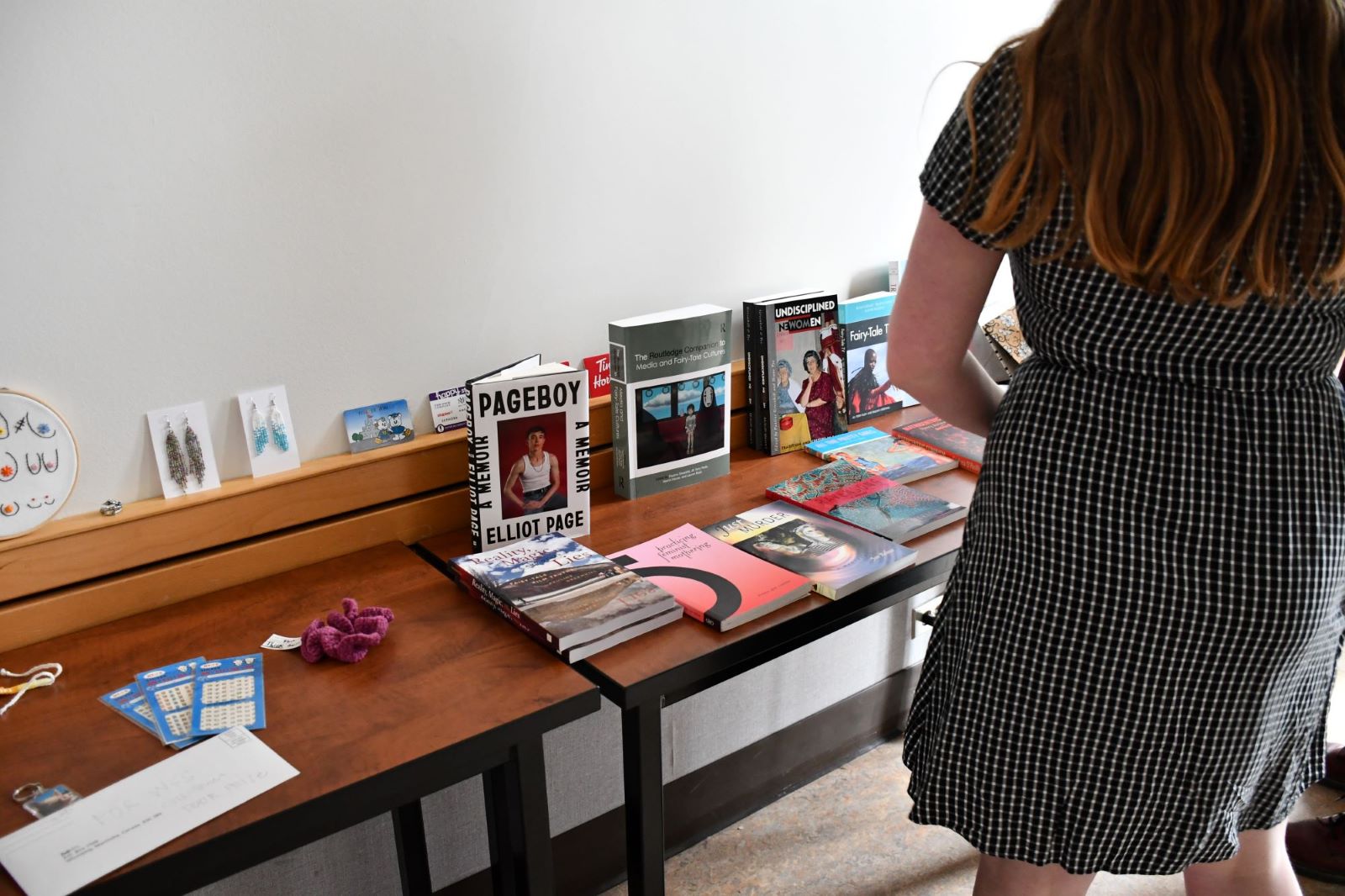 Katie checks out the awesome feminist door prizes (books, earrings, embroidery, etc.)