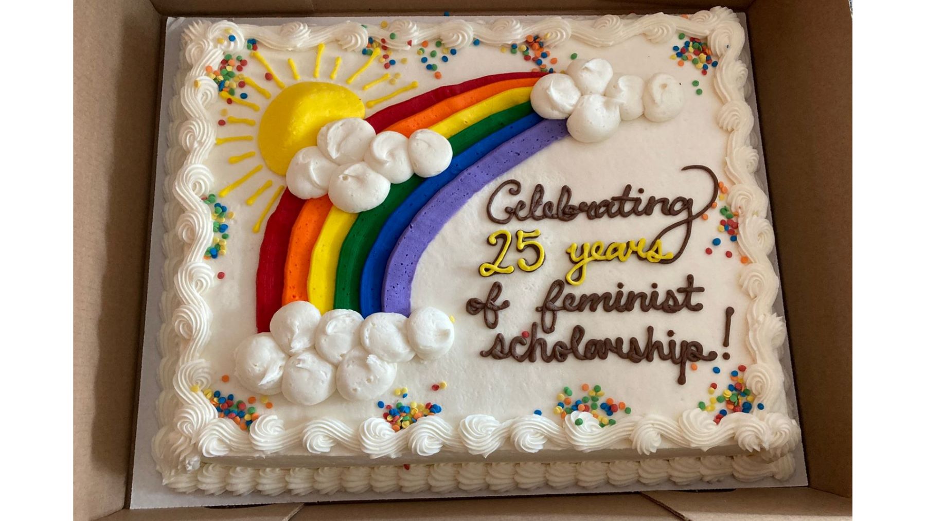 Cake with sun, rainbow and text: Celebrating 25 years of feminist scholarship!