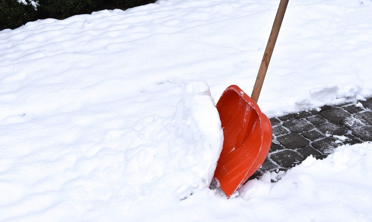 Red shovel being used on snow