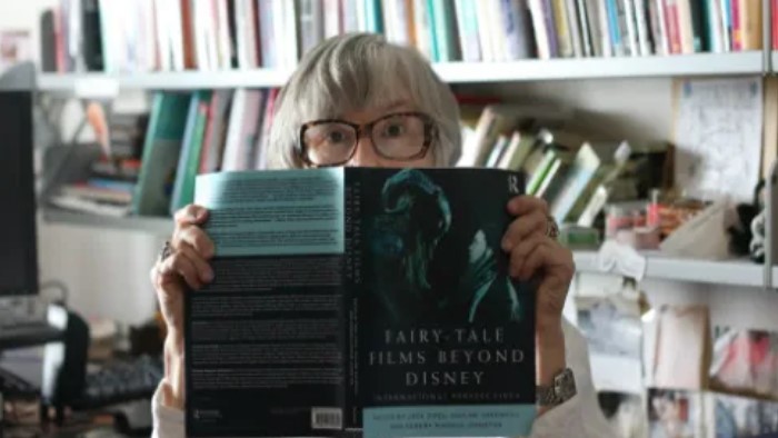 Prof. Pauline Greenhill holding a copy of her book, Fairy-Tale Films Beyond Disney